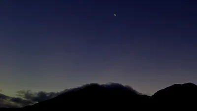 薄明の空に浮かぶ三日月と山