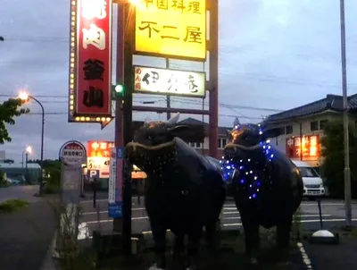 焼肉店前の牛のオブジェと夕暮れ