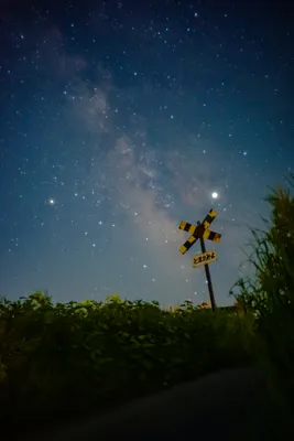 田舎道の星空と踏切看板